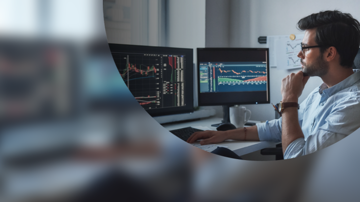a man sits at his desk reading reports on several monitors to help detect shadow it